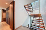 This stunning property boasts a modern staircase with sleek wooden steps and a glass railing, creating a seamless flow.