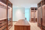 Step into luxury with this stunning walk-in closet, featuring custom wood cabinetry and ample storage space.