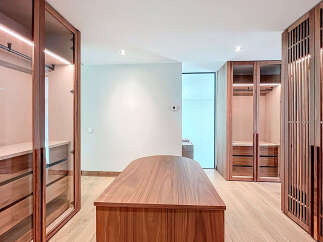 Step into luxury with this stunning walk-in closet, featuring custom wood cabinetry and ample storage space.