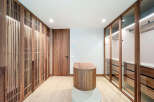 Step into luxury with this stunning walk-in closet, featuring custom wood cabinetry and ample storage space.