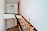 Discover the elegance of this modern staircase, featuring sleek glass railings and warm wooden steps.