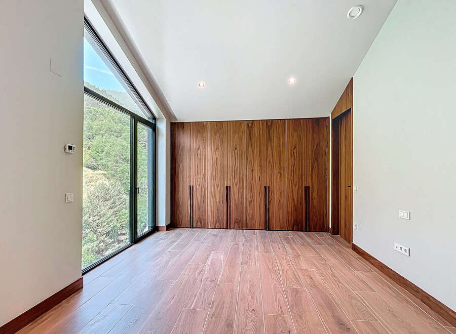 Discover a modern bedroom with stunning natural light and a serene view.
