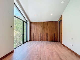 Discover a modern bedroom with stunning natural light and a serene view.