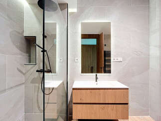 Modern bathroom design featuring a sleek shower with a rain showerhead and a stylish vanity.