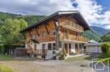 This stunning property boasts a charming wooden facade and offers a serene mountain view.