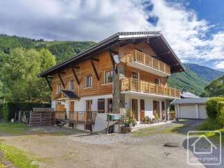 This stunning property boasts a charming wooden facade and offers a serene mountain view.