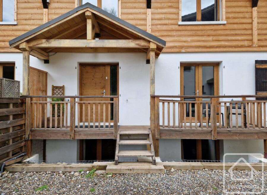 Discover this charming property featuring a welcoming wooden porch and a beautifully crafted wooden door.