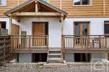 Discover this charming property featuring a welcoming wooden porch and a beautifully crafted wooden door.