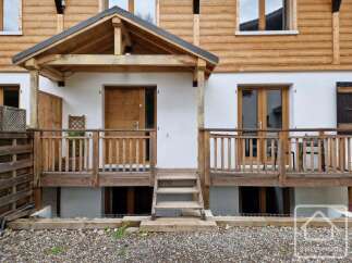 Discover this charming property featuring a welcoming wooden porch and a beautifully crafted wooden door.