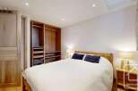 Discover the charm of this inviting bedroom, featuring a cozy bed and ample storage.