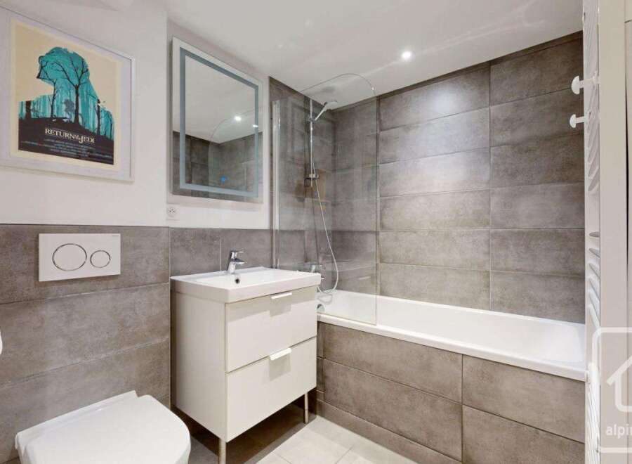 This modern bathroom features sleek gray tiling and a clean, minimalist design.