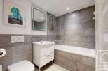 This modern bathroom features sleek gray tiling and a clean, minimalist design.