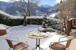 Enjoy the serene beauty of this snow-covered property with a charming outdoor seating area.