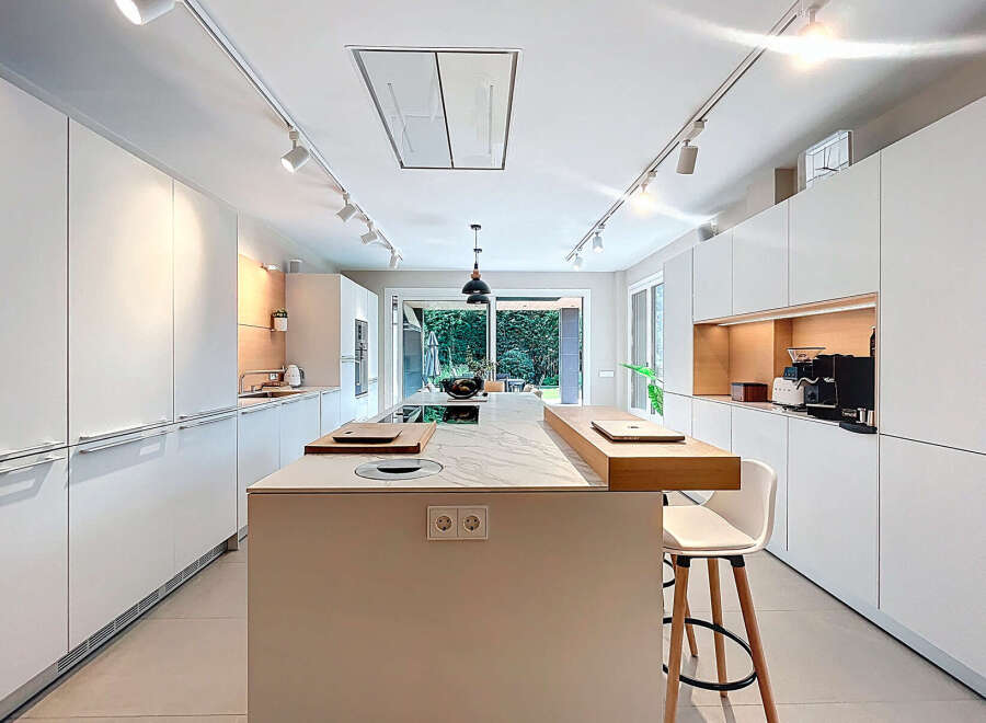 This modern kitchen boasts sleek, white cabinetry and a spacious island, perfect for culinary endeavors and entertaining.