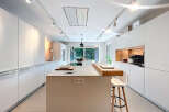 This modern kitchen boasts sleek, white cabinetry and a spacious island, perfect for culinary endeavors and entertaining.