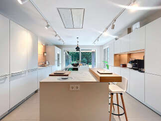 This modern kitchen boasts sleek, white cabinetry and a spacious island, perfect for culinary endeavors and entertaining.
