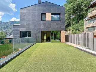 Modern architectural marvel showcasing a sleek facade with dark gray tiles and expansive glass windows.