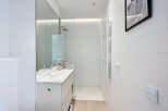 Discover a modern bathroom with sleek white tiles and a minimalist design.