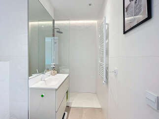 Discover a modern bathroom with sleek white tiles and a minimalist design.