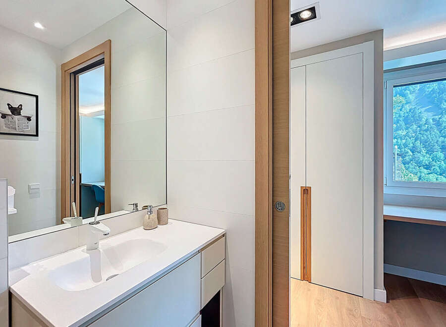 Modern bathroom design featuring a sleek white vanity and a large mirror.