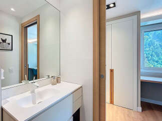 Modern bathroom design featuring a sleek white vanity and a large mirror.