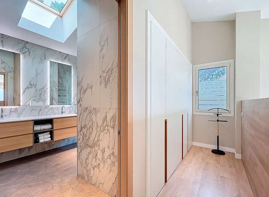 Step into luxury with this stunning property featuring a modern bathroom with marble accents and a skylight.