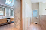Step into luxury with this stunning property featuring a modern bathroom with marble accents and a skylight.