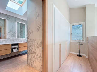 Step into luxury with this stunning property featuring a modern bathroom with marble accents and a skylight.