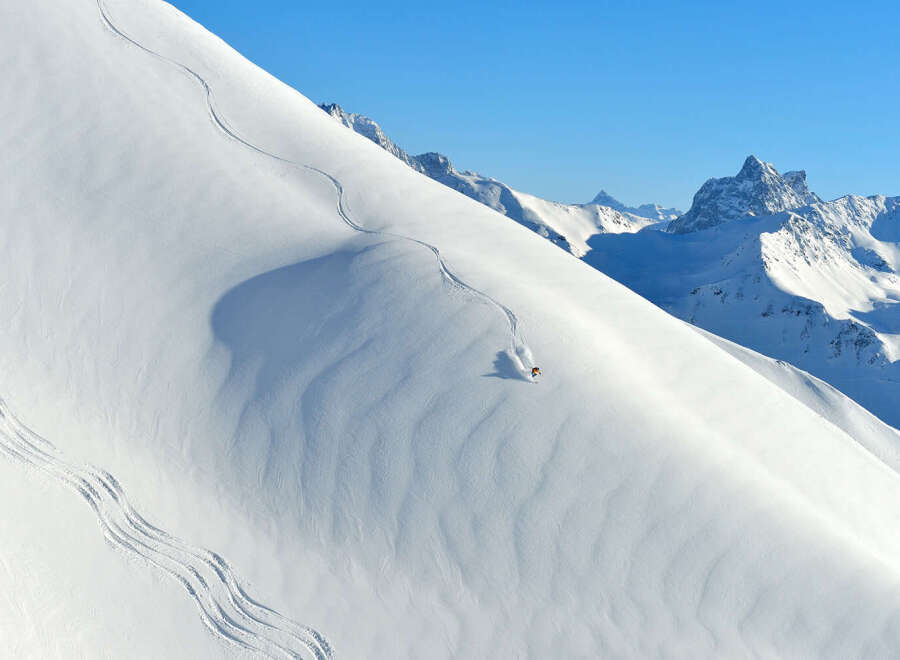 Experience the thrill of skiing down a pristine, snow-covered mountain.
