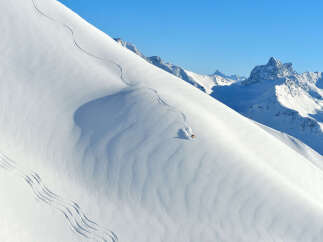 Experience the thrill of skiing down a pristine, snow-covered mountain.
