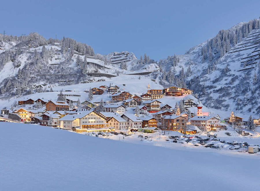Experience the charm of a snow-covered village nestled in the mountains.