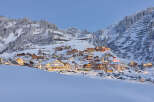 Experience the charm of a snow-covered village nestled in the mountains.