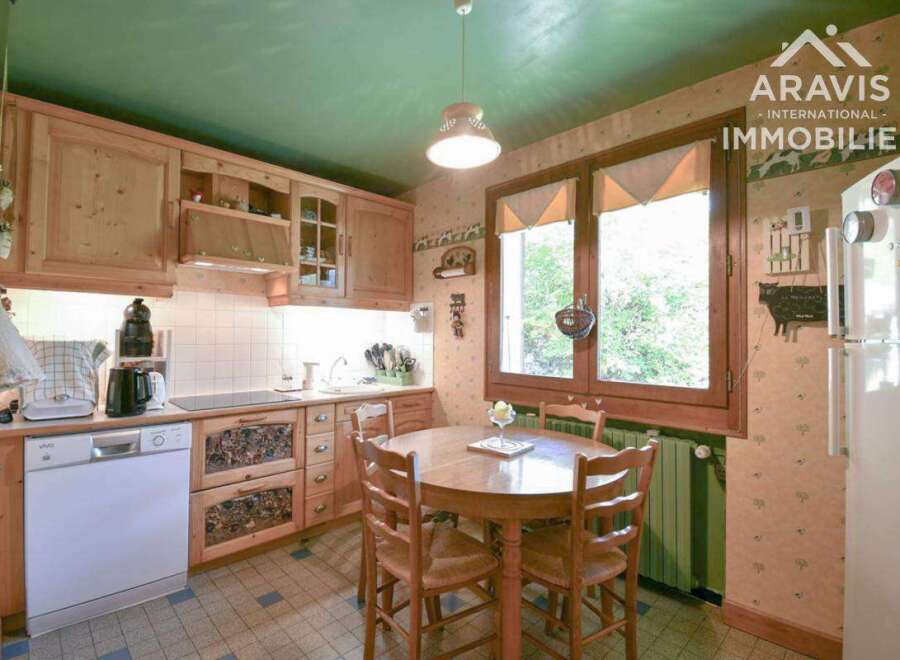 This charming kitchen features warm wooden cabinetry and a cozy dining area, perfect for family meals.