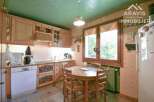 This charming kitchen features warm wooden cabinetry and a cozy dining area, perfect for family meals.