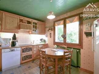 This charming kitchen features warm wooden cabinetry and a cozy dining area, perfect for family meals.