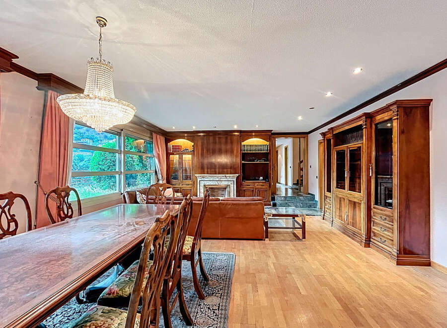 Elegant dining room with a stunning chandelier and a large wooden dining table.