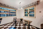 This charming kitchen features a sleek glass-top table, perfect for dining or working.