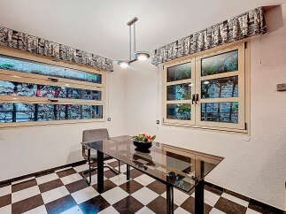 This charming kitchen features a sleek glass-top table, perfect for dining or working.