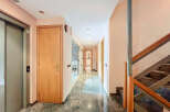 Discover a beautifully designed hallway with a modern elevator and elegant wooden doors.