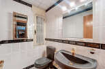This bathroom features a stylish design with white tiles and dark accents.