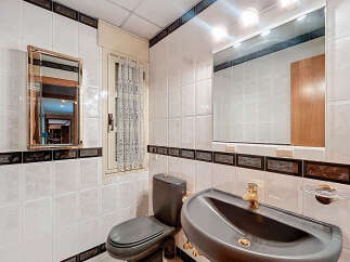 This bathroom features a stylish design with white tiles and dark accents.