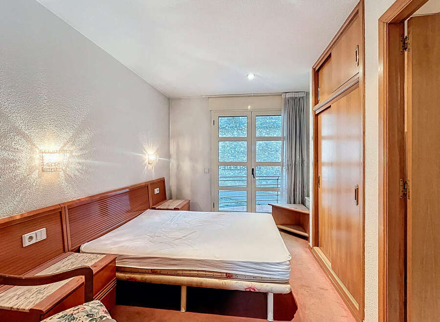 Discover a cozy bedroom with a comfortable bed and stylish wooden headboard.