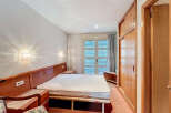 Discover a cozy bedroom with a comfortable bed and stylish wooden headboard.