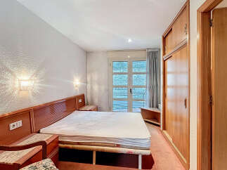 Discover a cozy bedroom with a comfortable bed and stylish wooden headboard.