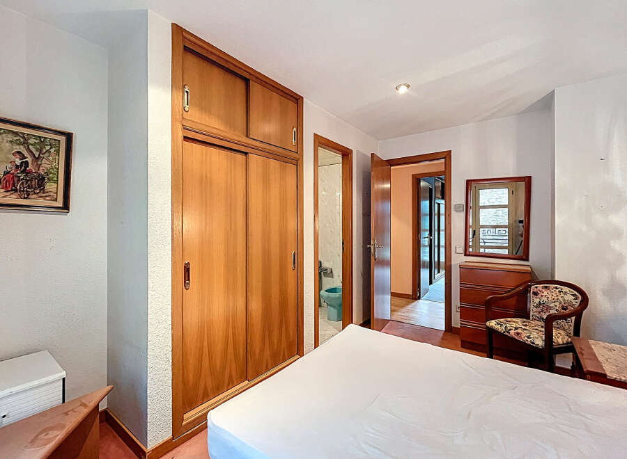 Discover this charming bedroom featuring a spacious wooden wardrobe, perfect for storage.