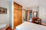 Discover this charming bedroom featuring a spacious wooden wardrobe, perfect for storage.