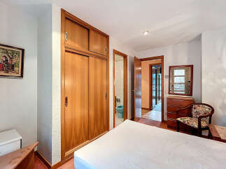 Discover this charming bedroom featuring a spacious wooden wardrobe, perfect for storage.