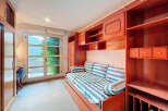 Discover a charming bedroom with a nautical theme, featuring a cozy bed with striped bedding and decorative pillows.