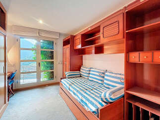 Discover a charming bedroom with a nautical theme, featuring a cozy bed with striped bedding and decorative pillows.
