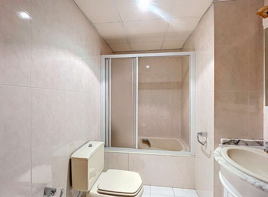 This bathroom features a clean and modern design with neutral-colored tiles.